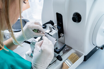 Laboratory assistant works on a rotary microtome section and making microscope slides