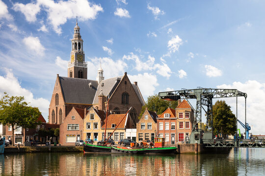 Port of Maassluis with old boats, church, drawbridge and monumental houses.