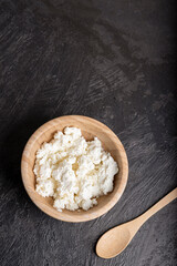 Requesón cuenco de madera, fondo oscuro.
