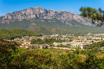 Fototapeta na wymiar view and of the town in a mountain valley (Kemer, Turkey) with Mount Tahtali (Lycian Olympus) in the distance