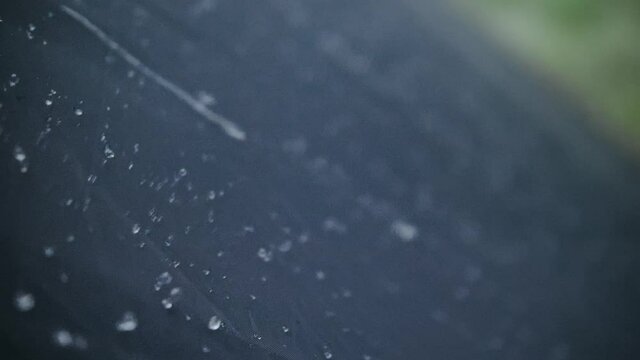 Close-up shot of raindrops water droplets on the tent. Dew drops on texture of fabric of tourist tent in rays of rising or setting sun. Camp tourism