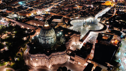 Aerial drone night shot of iconic masterpiece Saint Peter Basilica and whole illuminated city of...