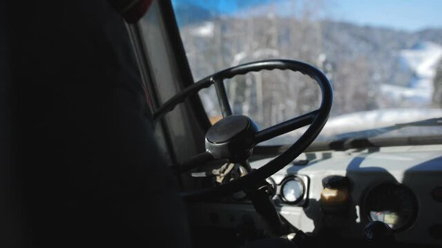 Close-up of the hands of a minibus driver driving a vehicle on a winter road.