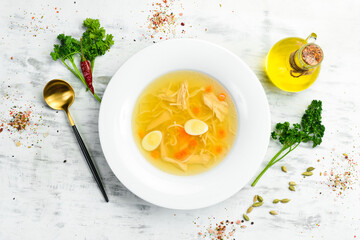 Quail soup. Quail meat broth with quail eggs and noodles. In a white plate. Top view.