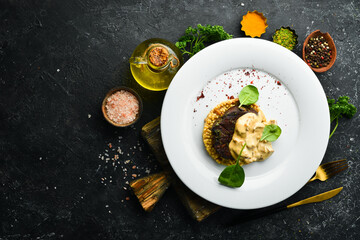 Beef steak with bulgur and mushrooms on a plate. Restaurant menu. European cuisine.
