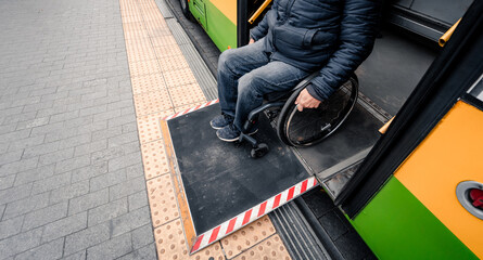 Person with a physical disability exits public transport with an accessible ramp.