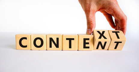 Content and context symbol. Businessman turns wooden cubes and changes the word context to content....