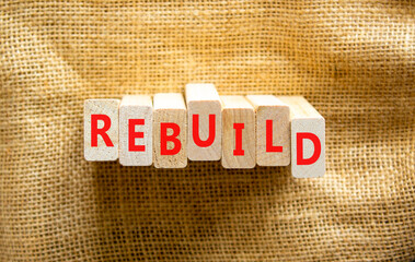 Rebuild and build symbol. The concept word Rebuild on wooden blocks. Beautiful canvas background, copy space. Business rebuild and build concept.