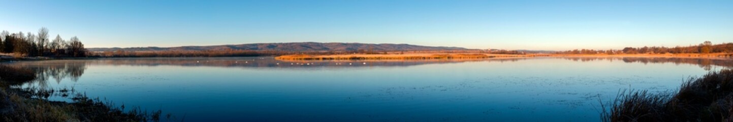 Fototapeta premium Panoramic view of a calm lake on a sunny summer day