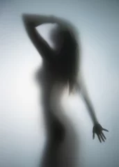 Beautiful perfect body woman stands behind a wet bathroom glass wall, Body silhouette. © Belphnaque