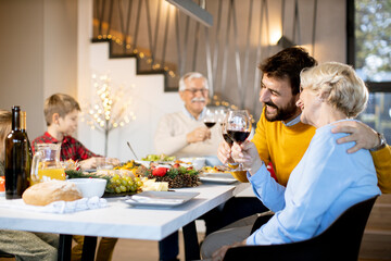 Happy family having dinner with red wine at home