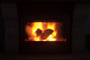 Logs of wood burning vividly in the fireplace.