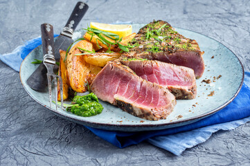 Traditional Japanese tuna tataki steak with hash browns and wasabi cream served as close-up on a Nordic design plate
