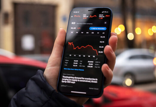 Kharkov, Ukraine - December 1, 2021: The Coca-Cola stock trade. Financial graphs, investment, digital banking concept. Smartphone with stock market app in hand