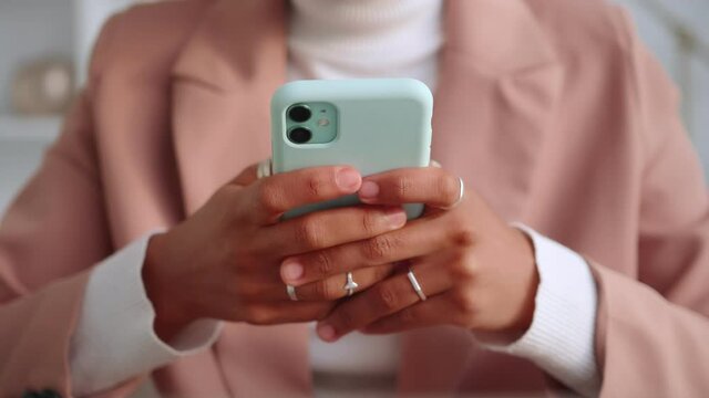 Close up of African woman hands typing message on smart phone in application for business correspondence. Female enjoy online chat, internet purchase, browse web, download new freeware application.
