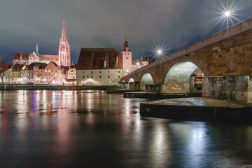 Steinerne Brücke und Donau Ufer mit Dom in der blauen Stunde beleuchtet mit Spiegelungen