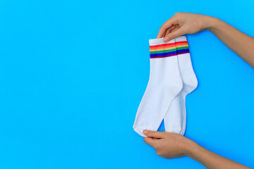 pair of rainbow-colored socks in blue background isolate .