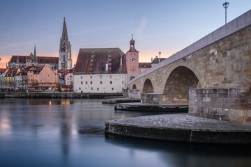 Fototapeta na wymiar Dom und steinerne Brücke in Regensburg bei Sonnenuntergang im Winter 