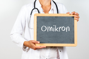 Ärztin mit einer Tafel auf der Omikron als neue Variante des Corona Virus