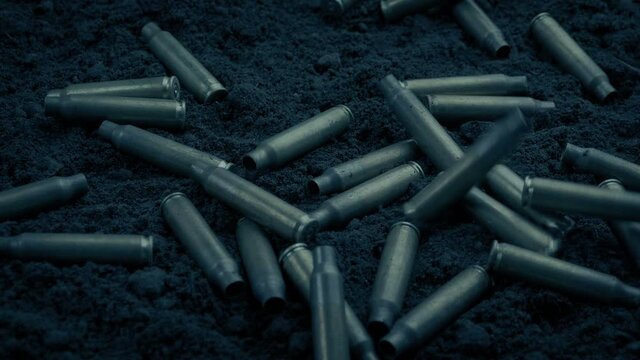 Machine Gun Cartridges Dropping To The Ground In The Dark