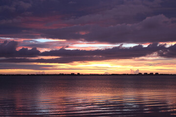 Fototapeta na wymiar Orange and Pink Sunset Skyline Over Ocean. Cloudy Dramatic Sunset Sky. 