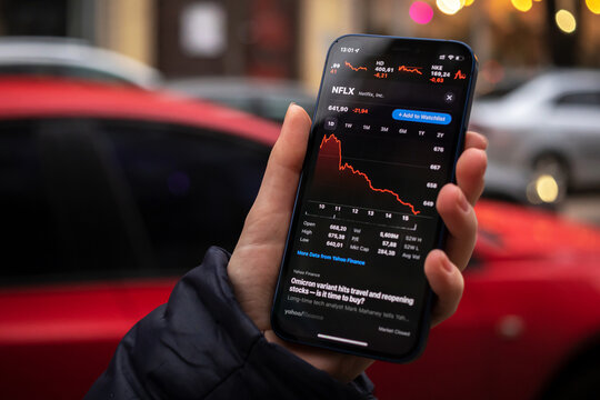 Kharkov, Ukraine - December 1, 2021: Netflix NFLX stock trade. Financial graphs, investment, digital banking concept. Smartphone with stock market app in hand