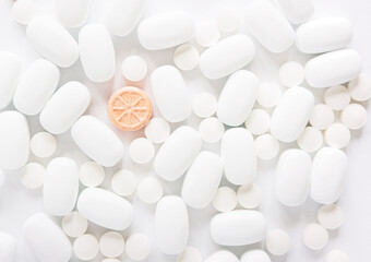 White pills on a white background. Oblong and round pills close-up. Healthcare and medicine.