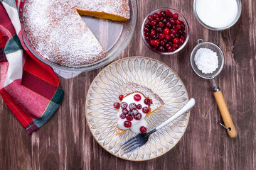 Piece of Swedish saffron Kladdkaka pie with white chocolate, whipping cream and cranberry horizontal