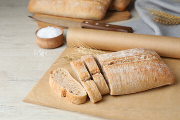 Fresh crispy ciabatta on white wooden table