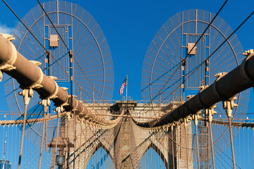 The national flag of United States of America winding on top of Brooklyn Bridge landmark from...