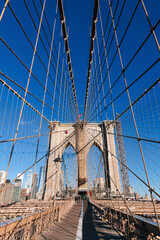 New York, USA - 2021: Brooklyn Bridge, built in 1883, was the first fixed crossing of the East River. Photo taken during the day with blue sky and view to the beautiful Manhattan.