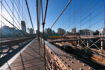 Obraz premium New York, USA - 2021: Brooklyn Bridge, built in 1883, was the first fixed crossing of the East River. Photo taken during the day with blue sky and view to the beautiful Manhattan.