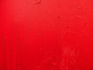 Scratched vivid red paint surface close-up.