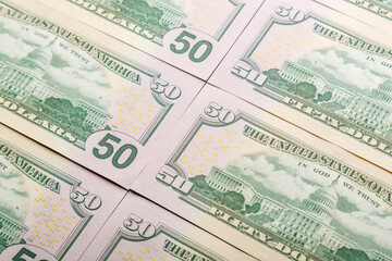 Close-up of fifty dollar bills spread out on the table fragments.