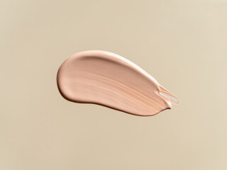 Liquid foundation isolated on beige nude background. Smear of foundation for face. Cosmetic smear...