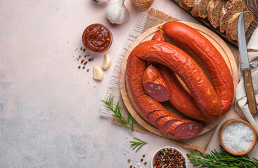 Krakow sausage with spices, sauce and bread on a light background.