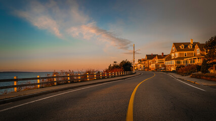 Hilltop village and cape-style houses on the winding road in the shorelines in Atlantic Ocean. Sunrise seascape on Cape Cod.