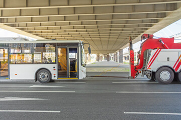 Repair and recovery vehicle evacuation, towing a broken city bus.