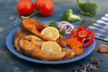 Christmas carp, Fried carp fish slices on a blue plate.  Fried golden crust fish fillets with  lemon and vegetables.
