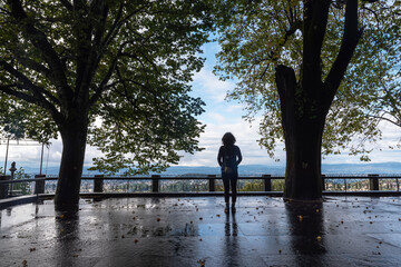 Woman looks at the horizon between trees