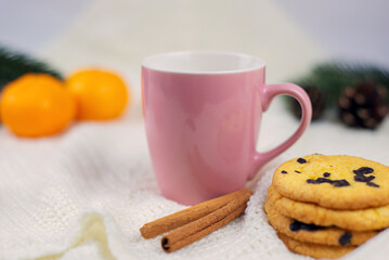 Details of a still life in a home interior. Sweater, a cup of tea, a candle. Cozy winter concept.