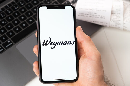 Wegmans mobile application of supermarkets and grocery chains is opened in a smartphone. Buying groceries online. A man uses a food delivery service in smartphone app November 2021, San Francisco, USA