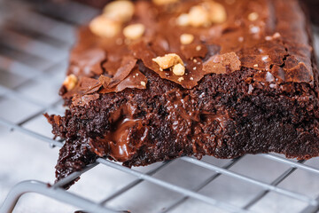 Close up of Chocolate brownies with hazelnut crumbs on top, on a tray with cacao powder, chocolate...