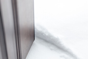 Large layer of snow behind an open door after a heavy snowfall