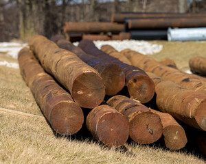 Stack of wooden electrical utility poles ready for installation. Concept of electrical utility...