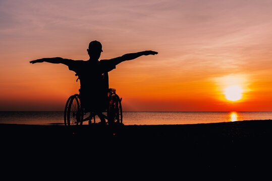 Behind of people with disability looking sunset on the sea beach at summer, Positive photos give life energy and power concept.