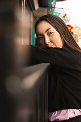 Portrait of attractive and happy smiling young Asian woman looking to camera on the street