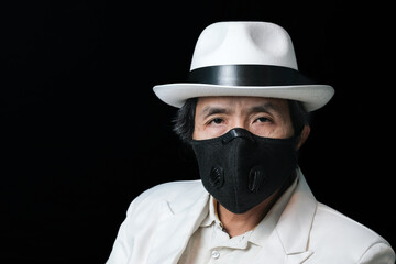 Close-up portrait of a masked man against black background