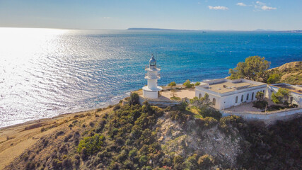 Fototapeta na wymiar Faro del Cabo de las Huertas en Alicante , vista aérea en un día luminoso y con el mar peinado por el fuerte viento de poniente y con un fuerte color azul del mar.