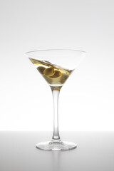 Vermouth glass in motion with olives on a white background